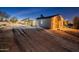 Exterior of desert home with the garage on the right and patio in the middle at twilight at 15612 S Tuthill Rd, Buckeye, AZ 85326