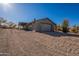 Charming home featuring a large gravel driveway, mature desert landscaping and attached garage at 15612 S Tuthill Rd, Buckeye, AZ 85326
