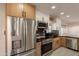 Bright kitchen showcasing stainless steel appliances, and a combination of white and wood cabinets at 15612 S Tuthill Rd, Buckeye, AZ 85326