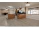 Open concept kitchen with stone countertops and adjacent living space with fireplace at 15612 S Tuthill Rd, Buckeye, AZ 85326