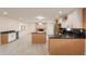 Open concept kitchen featuring stainless appliances, black countertops and a bright adjacent dining room at 15612 S Tuthill Rd, Buckeye, AZ 85326