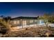 Rear exterior of desert home with large patio and desert vegetation at twilight at 15612 S Tuthill Rd, Buckeye, AZ 85326