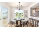 Dining area featuring modern decor, wood floors, elegant lighting fixture, and view to the fenced backyard at 1605 W Curry Dr, Chandler, AZ 85224