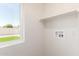 Bright laundry room with a large window, utility connections, and built-in shelving at 1605 W Curry Dr, Chandler, AZ 85224