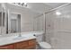 Bathroom with a wood vanity, sink, a toilet, and a glass-enclosed shower at 16619 W Cottonwood St, Surprise, AZ 85388