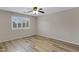 Bright bedroom featuring wood-look flooring, shuttered window and lighted ceiling fan at 16619 W Cottonwood St, Surprise, AZ 85388