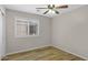 Bedroom with wood floors, a ceiling fan, and a large window with blinds at 16619 W Cottonwood St, Surprise, AZ 85388