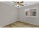 Bedroom featuring wood floors, a ceiling fan, and a window with blinds at 16619 W Cottonwood St, Surprise, AZ 85388