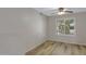 Bedroom with wood-look flooring, lighted ceiling fan and shuttered window at 16619 W Cottonwood St, Surprise, AZ 85388