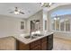 Kitchen island with a double sink, dark wood cabinets, and stainless steel dishwasher at 16619 W Cottonwood St, Surprise, AZ 85388