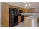 Bright kitchen with a black refrigerator, wood cabinets, and modern appliances at 16619 W Cottonwood St, Surprise, AZ 85388