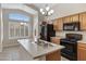 Kitchen with wood cabinets, stainless steel appliances, an island, and lots of natural light at 16619 W Cottonwood St, Surprise, AZ 85388