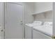 Bright laundry room with door to exterior, shelving and side-by-side washer and dryer at 16619 W Cottonwood St, Surprise, AZ 85388