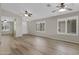 Open living room with hardwood floors, ceiling fans and natural light from large windows at 16619 W Cottonwood St, Surprise, AZ 85388
