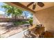 Covered patio with outdoor seating overlooking a grassy backyard and mature trees at 18149 W Turney Ave, Goodyear, AZ 85395