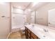 Bright bathroom features dual sinks, a bathtub, and shower with modern fixtures and neutral tones at 18149 W Turney Ave, Goodyear, AZ 85395
