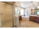 Well-lit bathroom featuring a soaking tub, glass shower, and -and- vanity sinks at 18149 W Turney Ave, Goodyear, AZ 85395
