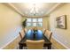 Bright dining room boasts large windows, neutral walls, and a modern chandelier above the dark wood table at 18149 W Turney Ave, Goodyear, AZ 85395