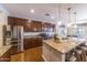 Open kitchen featuring granite countertops, a stainless steel refrigerator, and breakfast bar seating at 18149 W Turney Ave, Goodyear, AZ 85395