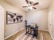 Office featuring a dark desk, ceiling fan, tiled floors, and a stylish world map wall decoration at 18149 W Turney Ave, Goodyear, AZ 85395