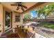 Inviting covered patio with ceiling fan and dining table overlooking the landscaped backyard at 18149 W Turney Ave, Goodyear, AZ 85395