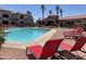 Relaxing pool area with bright red lounge chairs and clubhouse in the background at 1941 S Pierpont Dr # 1014, Mesa, AZ 85206