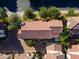 Aerial view of a home with a red tile roof, brick driveway, green grass, and beautiful landscaping at 1941 W Yellowstone Way, Chandler, AZ 85248