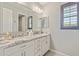 Bright bathroom featuring a double vanity with granite countertops and white cabinets at 1941 W Yellowstone Way, Chandler, AZ 85248