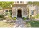 Inviting entryway with brickwork, arched doorway, and landscaped garden leading to a wooden front door at 1941 W Yellowstone Way, Chandler, AZ 85248