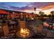 Inviting outdoor patio with comfortable seating around a cozy fire pit and vibrant sunset colors in the sky at 1941 W Yellowstone Way, Chandler, AZ 85248