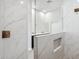 Modern bathroom features glass shower with white marble-style tiling and dark vanity at 19550 N Grayhawk Dr # 1144, Scottsdale, AZ 85255