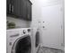 Well-equipped laundry room with modern washer and dryer, storage cabinets, and tiled floor at 19550 N Grayhawk Dr # 1144, Scottsdale, AZ 85255