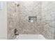 Modern shower with neutral tile, a built-in shelf, and chrome fixtures at 19550 N Grayhawk Dr # 1144, Scottsdale, AZ 85255