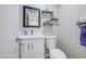 Charming powder room with modern sink, toilet, shelving and decorative mirror at 2041 E Des Moines St, Mesa, AZ 85213