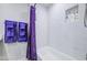 Bathroom featuring white marble tiles, a shower with shelf, and stylish purple accents at 2041 E Des Moines St, Mesa, AZ 85213