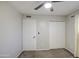 Bright bedroom features a ceiling fan, closet, and fresh paint creating a clean, inviting space at 2041 E Des Moines St, Mesa, AZ 85213