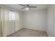 Minimalist bedroom with a ceiling fan, neutral carpet and curtains, and natural light at 2041 E Des Moines St, Mesa, AZ 85213