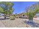 A low-maintenance front yard provides beautiful desert landscaping and trees at 2041 E Des Moines St, Mesa, AZ 85213
