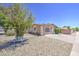 The low-maintenance front yard features desert landscaping and a cute decorative bench at 2041 E Des Moines St, Mesa, AZ 85213