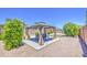 Outdoor gazebo with seating and privacy drapes, surrounded by green foliage and a gravel surface at 2041 E Des Moines St, Mesa, AZ 85213