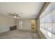 Bright living room featuring neutral walls, carpet flooring, and a ceiling fan at 2041 E Des Moines St, Mesa, AZ 85213