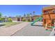 Backyard view of a playground set with slide and swings, next to a grassy lawn and a house at 2041 E Des Moines St, Mesa, AZ 85213
