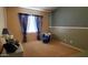 Bedroom with accent wall, blue drapes, sitting chair, and neutral carpet at 2101 S Meridian Rd # 437, Apache Junction, AZ 85120