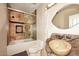 Bathroom showcasing a unique stone sink and a tiled shower with glass door at 21609 N 61St Ave, Glendale, AZ 85308