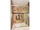 Detailed view of a tiled shower/tub combo with integrated shower heads and seat at 21609 N 61St Ave, Glendale, AZ 85308