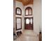 Bright entryway featuring tile flooring, a wooden door, arched windows, and a brick wall at 21609 N 61St Ave, Glendale, AZ 85308