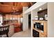 Kitchen featuring granite counters, stainless appliances, and wood cabinetry with brick accent walls at 21609 N 61St Ave, Glendale, AZ 85308