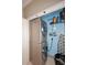 Modern laundry closet featuring stacked washer and dryer, storage shelves, and ironing board at 21609 N 61St Ave, Glendale, AZ 85308