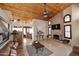 Spacious living room showcasing a wood-paneled ceiling, brick fireplace and seamless transition to the kitchen at 21609 N 61St Ave, Glendale, AZ 85308