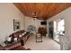 Cozy living room showcasing wood-paneled ceilings, tile floors and a seamless transition to the backyard at 21609 N 61St Ave, Glendale, AZ 85308